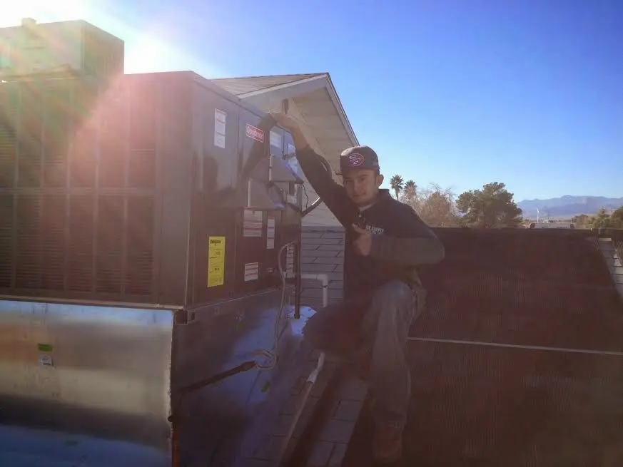 HVAC technician performing Boiler Repair on a rooftop unit in Bonham